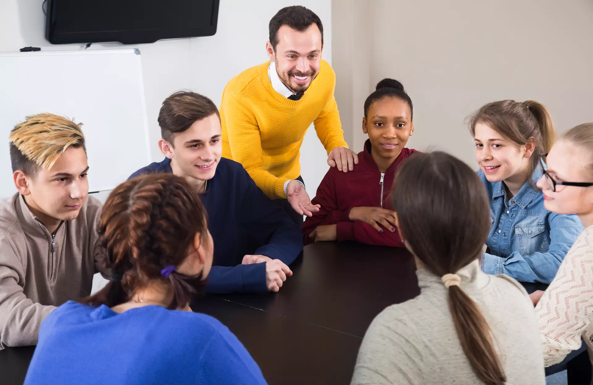 Un adulte discute avec de jeunes adolescents.