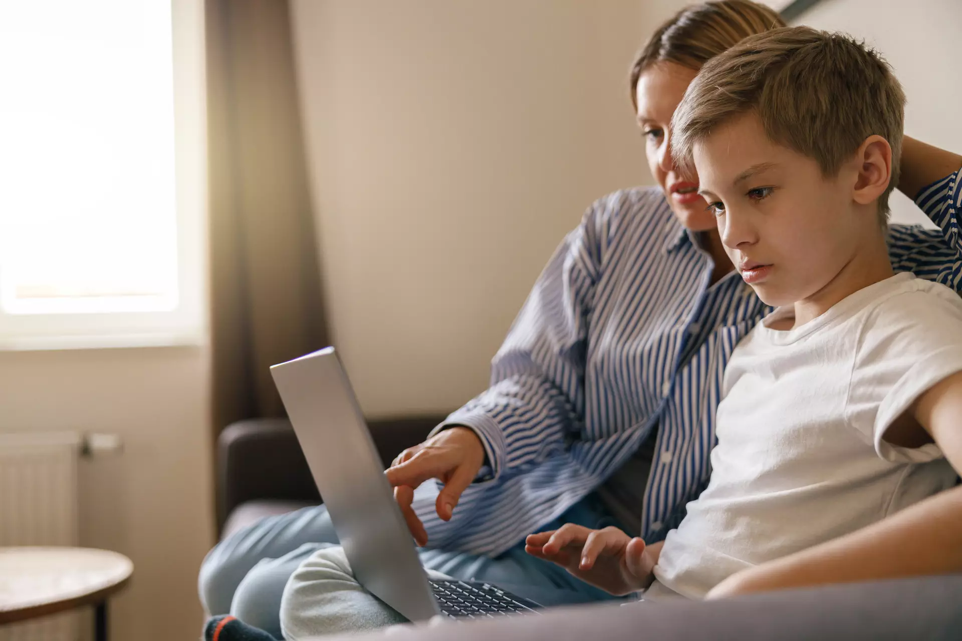 Parent et enfant regardant un écran d’ordinateur.